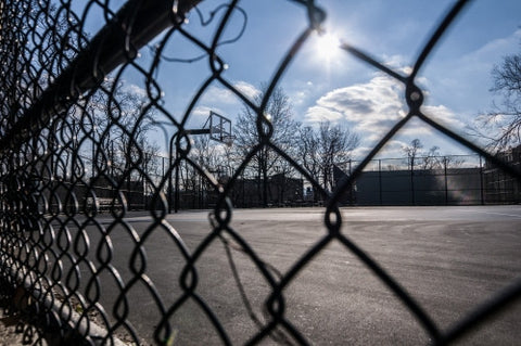 gritty fence and Harlem basketball court on sunny winter day