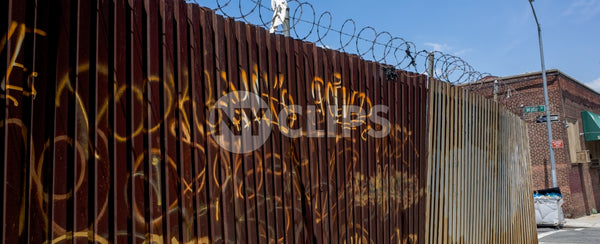rusty fence gate with gritty graffiti in Brooklyn