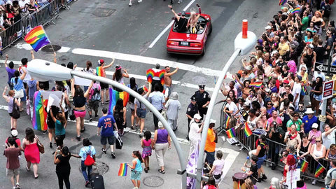 Gay Pride Parade - LGBT March - convertible with people celebrating - rainbow flags in NYC