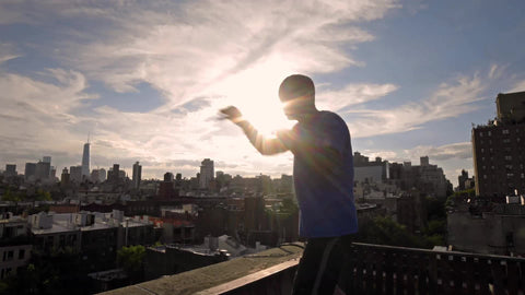 man sparring on rooftop with Manhattan skyline at sunset in NYC