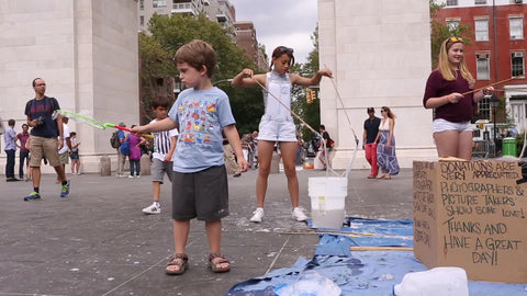 kids playing with bubbles in Washington Square Park on summer day in NYC