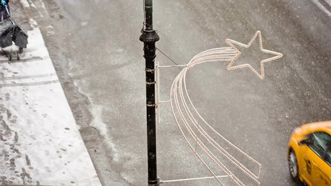 taxi cab and mailman delivering mail in snow on winter blizzard day from high view of street