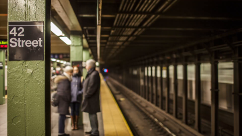 42nd Street subway station with train entering and leaving and people on crowded platform - 4K timelapse in NYC