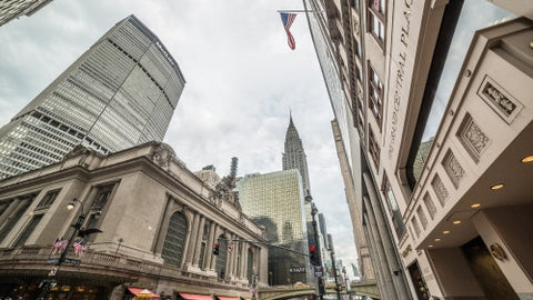 MetLife skyscraper, Grand Central Station Terminal and Chrysler Building in Midtown Manhattan - American flag - upward angle in early evening on summer day