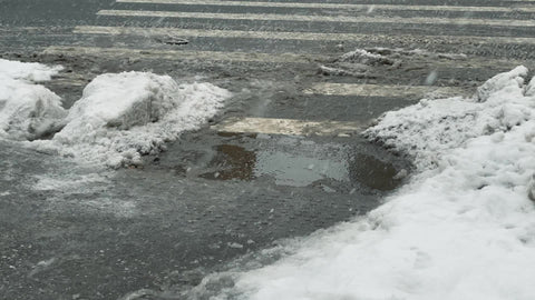 family walking around puddle - avoid ice and walk on snow in cold wet winter New York City