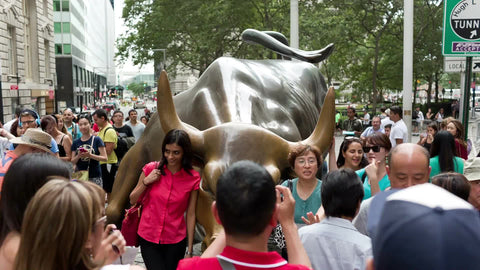 Wall Street Bull sculpture in Lower Manhattan - Financial District with tourists on summer day in NYC
