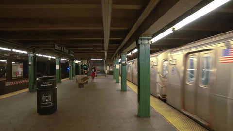 kid bouncing basketball - dribbling ball in West 4th St subway station with train departing platform