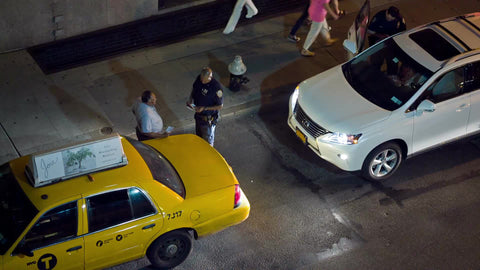 taxi cab driver and police officer having conversation on street at night
