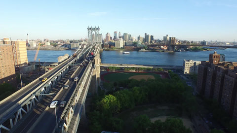 aerial of Manhattan Bridge and East River on beautiful sunny day - cars driving to Brooklyn