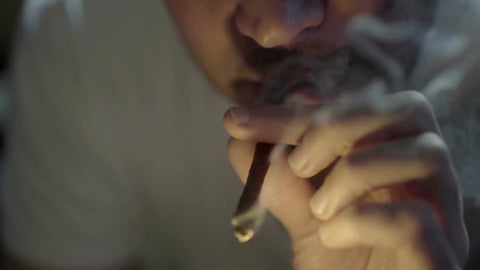 man lighting blunt and smoking - puffing marijuana - guy blazing weed