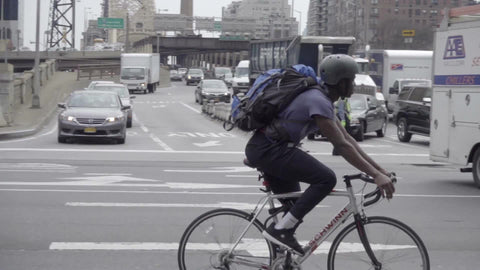 man on bicycle riding on east side of Manhattan in traffic in 1080 HD NYC