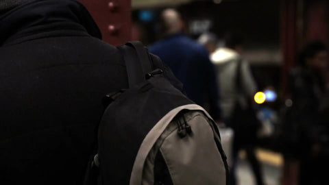 man with backpack waiting on subway station platform