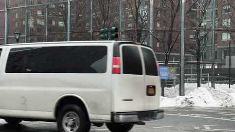driving past gritty park with fence - kids playing after school with snow in winter Downtown Manhattan New York City NYC