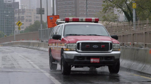 emergency FDNY vehicle driving on wet rainy highway road on fall day - raining in NYC