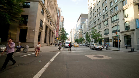 taxi cab driving down Lower 5th Avenue on sunny summer day in Manhattan