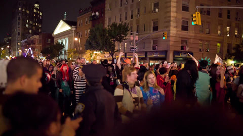 monsters and goblins and ghouls in costumes marching in Halloween parade in Greenwich Village on 6th Ave