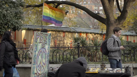 rainbow flag for LGBT peace - gay colors at Union Square with diverse variety of people walking by in slow motion