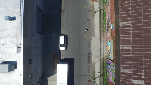 aerial over skater - skating through Brooklyn neighborhood - sunny street in NYC