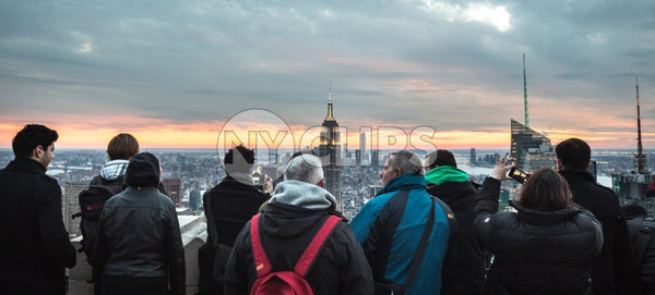 tourists taking photo of Empire State Building in Manhattan observation deck at sunset NYC