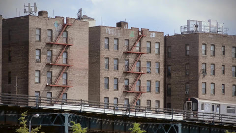 subway elevated in the South Bronx with tenement houses fire escape buildings New York City NYC