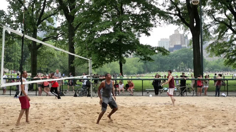 volleyball in Central Park - man spiking ball over net on summer day