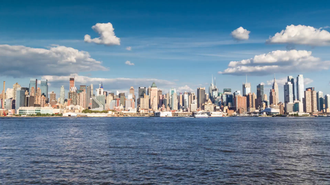 Manhattan skyline from day to sunset to night across East River water - 4K timelapse of skyscrapers
