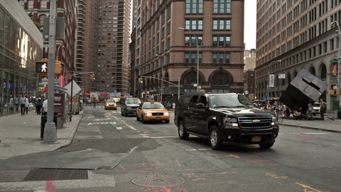 cars driving past cube sculpture in Cooper Square toward East Village during day in Manhattan NYC