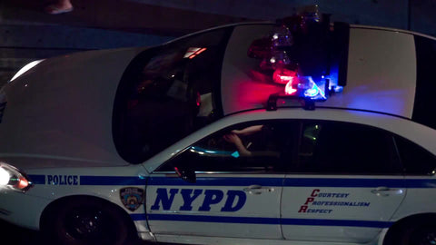 overhead view of flashing turret lights on cop car - NYPD police vehicle driving at night
