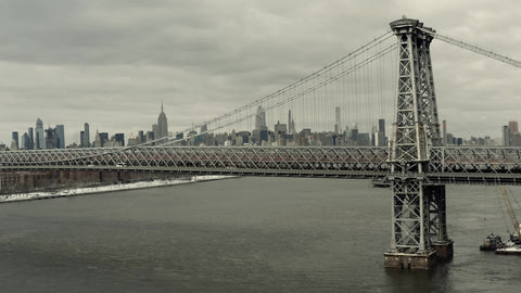 aerial of cars driving on Williamsburg Bridge from Manhattan to Brooklyn with Empire State Building in drone skyline cityscape New York City NYC
