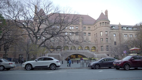 American Museum of Natural History side entrance cars driving by afternoon establishing shot