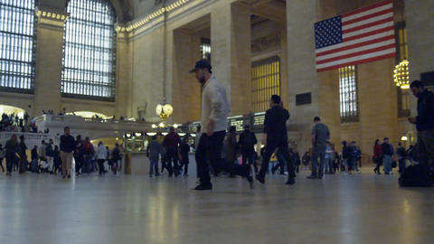 breakdancer doing windmills in Grand Central Station Terminal interior - breakdancing in front of American Flag in 4K NYC