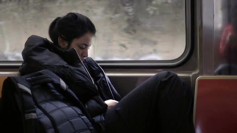 girl riding subway - elevated B train with graffiti view through window in NYC