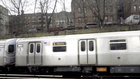 subway train across elevated tracks passing, revealing graffiti on ghetto wall from B train in Brooklyn 1080 HD in NYC