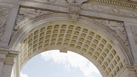 NYU students pillow fight in Washington Square Park, tilting down from famous arch in NYC