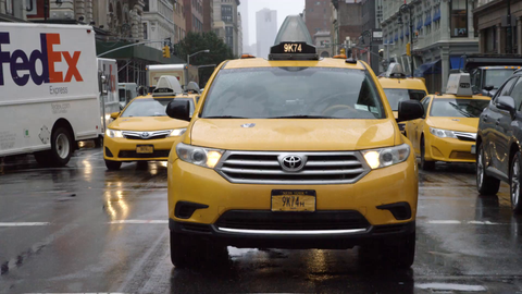 taxicabs driving in rain - raining on taxi in traffic during day - Manhattan NYC