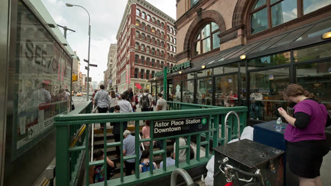 people exiting Astor Place subway station on summer day with Starbucks upstairs in NYC