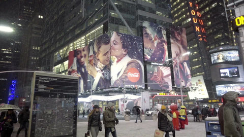 Supreme Court Justice Scalia death ticker news - panning through Times Square - snowing at night - people walking - tourists winter NYC