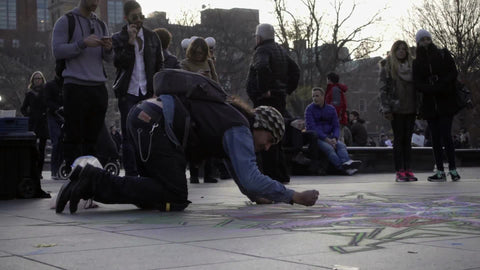 chalk artist in Washington Square Park in late afternoon making beautiful images on ground