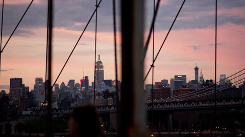 Empire State Building and Manhattan skyline - beautiful sunset view from Brooklyn Bridge in early evening in NYC
