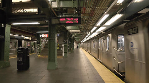 subway train departing station platform at Times Square stop in NYC
