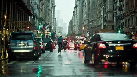 raining on cars in traffic on 5th Ave in early evening in Manhattan NYC