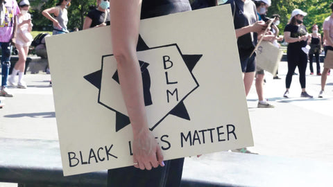 White woman carrying Black Lives Matter sign at rally in New York City