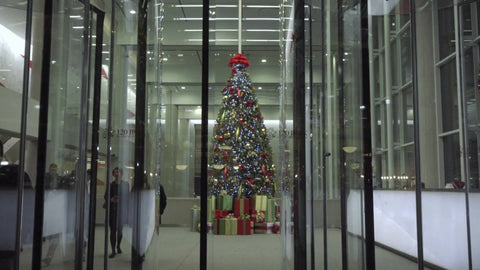 Christmas tree in corporate office building behind revolving door on holidays