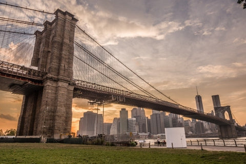 Brooklyn Bridge and Manhattan skyline during the day - beautiful orange sky at sunset in NYC