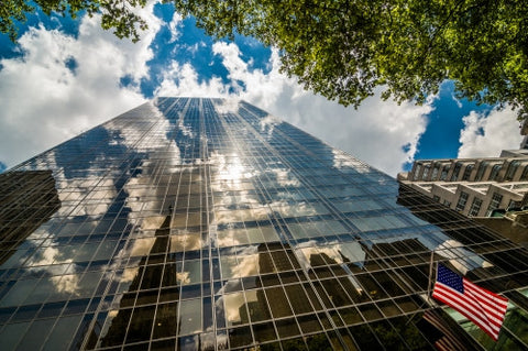 glass corporate office building and American flag - upward view