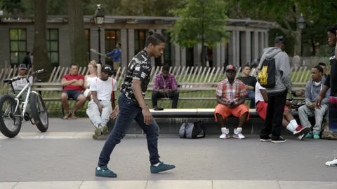 kid breakdancing in Washington Square Park doing windmills spinning around