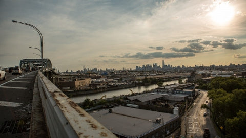 Kosciuszko Bridge with view of Manhattan skyline and late afternoon early evening sun before sunset