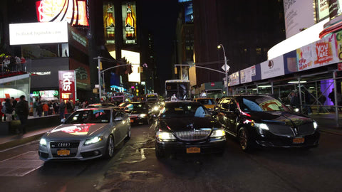 cars driving in slow motion through Times Square bright lights at night in Manhattan NYC
