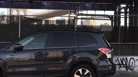 gritty no parking signs under FDR Drive by East River with Brooklyn Bridge and buildings across water Downtown Manhattan New York City NYC