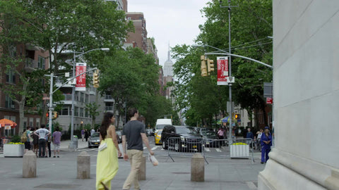 couple walking under Washington Square Park arch on summer day in NYC